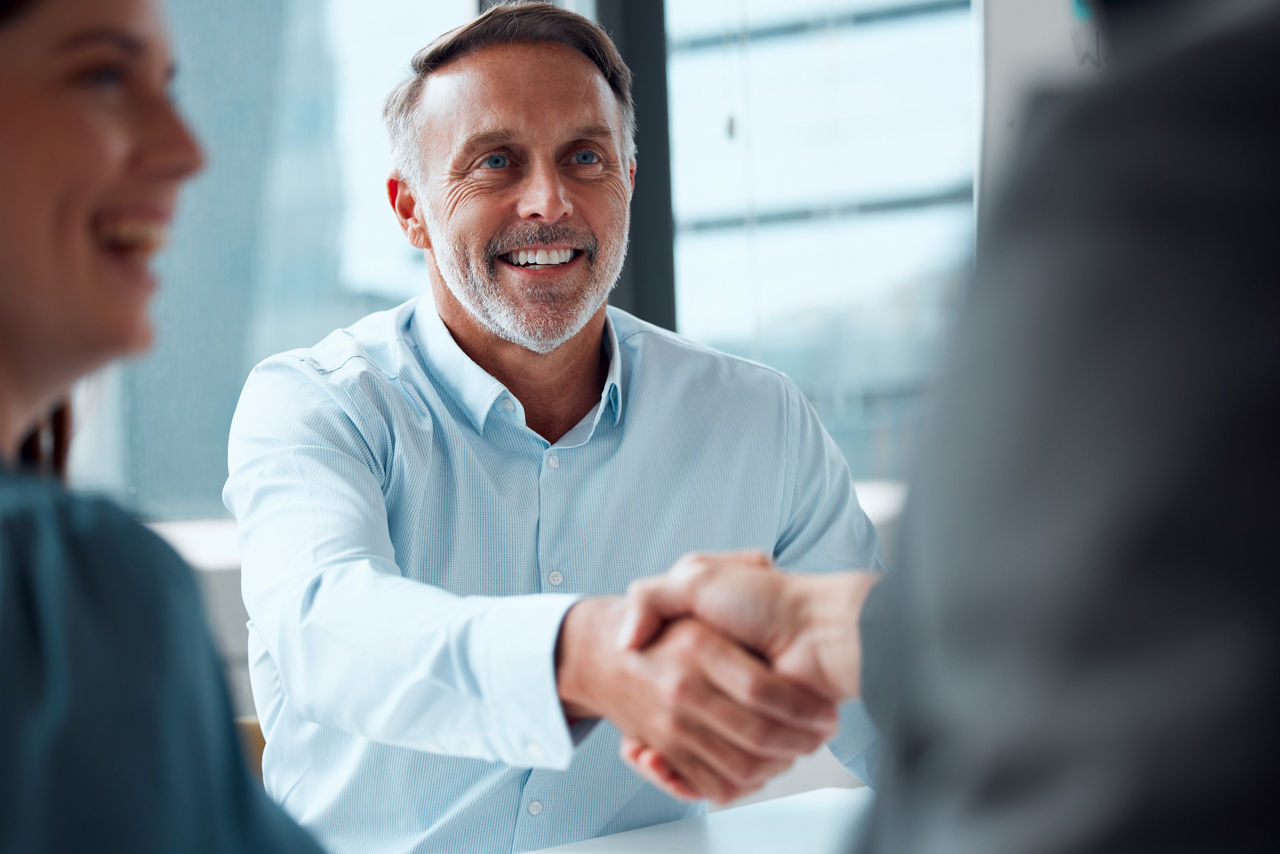 Shot of a mature businessman shaking hands with a colleague during a meeting in an office.