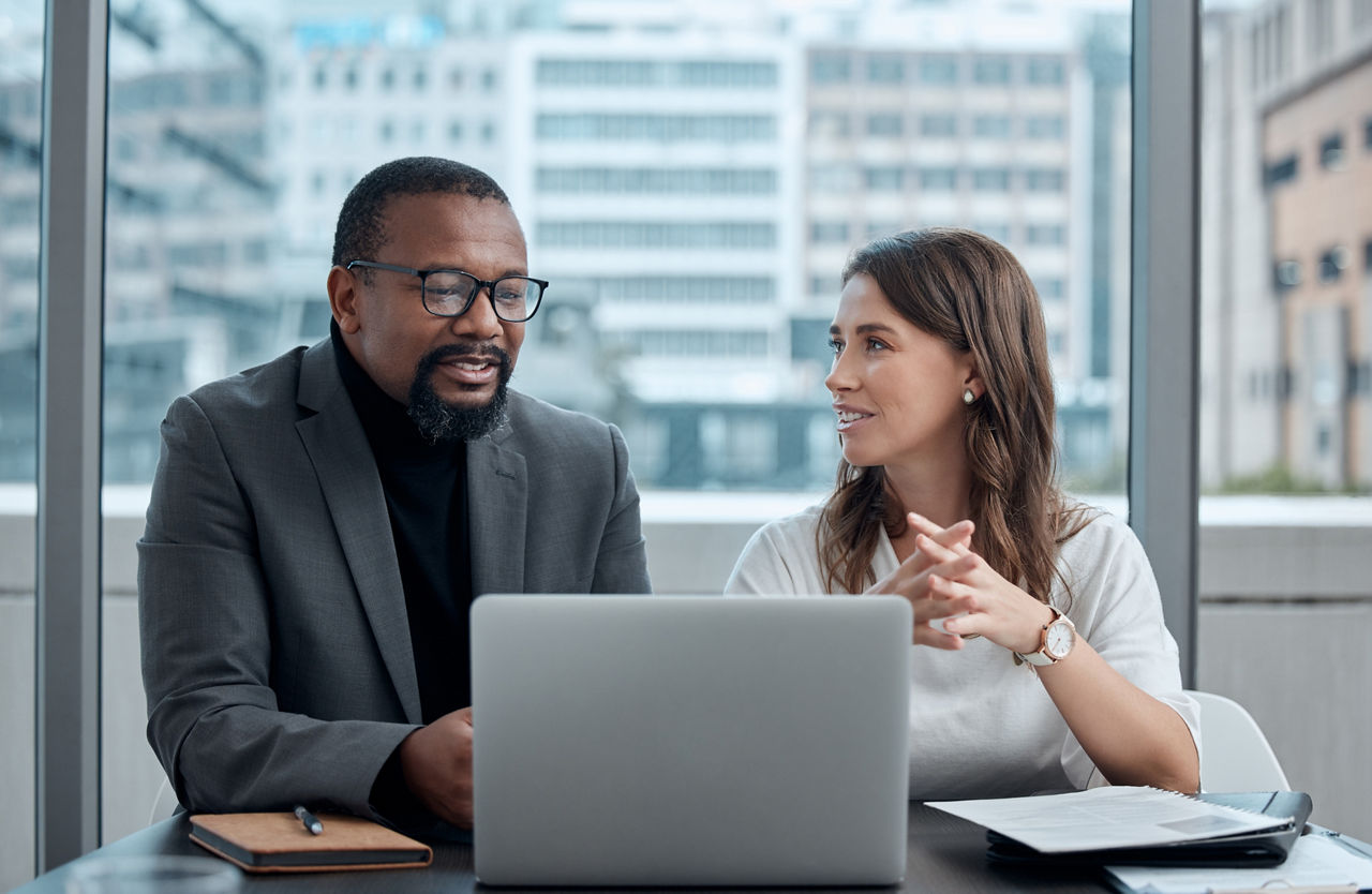 Cropped shot of two corporate business colleagues having a meeting around the table in the boardroom.